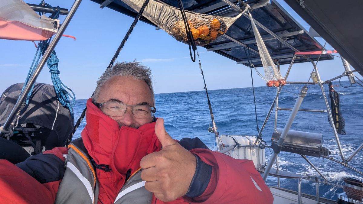 Wache im Cockpit auf offener See, Angel ausgebracht, Proviantnetz unter dem Bimini