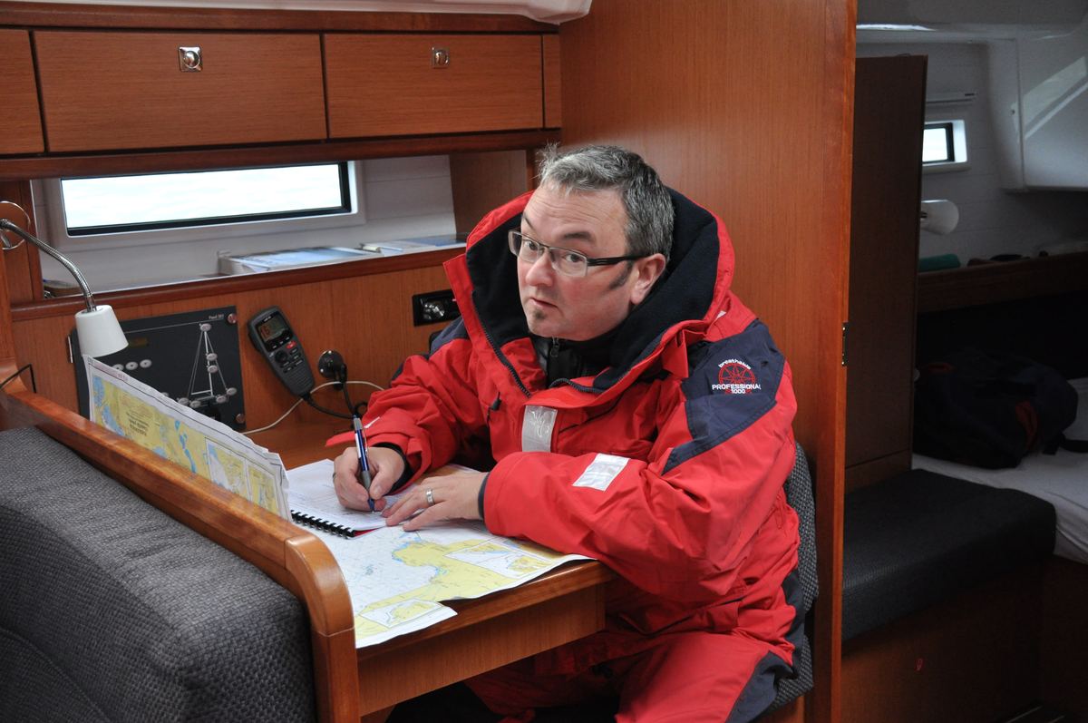 Navigation am Kartentisch unter Deck, Seekarte, Koppelbesteck und Funkgerät